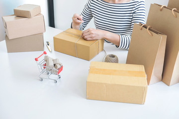Fototapeta premium Internet online shopping concept, Young seller woman preparing package to be sent Mail transportation, service network connection market, technology on global, Order online for customer convenience