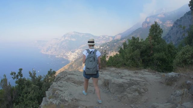 Italy. The Amalfi coast. A tourist on the edge of the cliff.