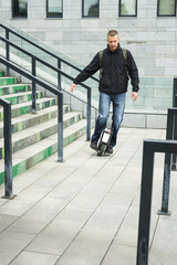 Casual man riding on one wheel electronic monocycle in the city.