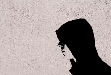 Foto op Aluminium Young teenage bully boy in black hoodie with graffiti stencil effect on white concrete textured wall © Ole