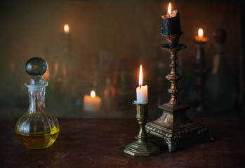 Magic potion, ancient books and candles on dark background