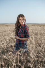 Naklejka na ściany i meble Beautiful girl in brunette field, with long brunette hair, relaxing in nature, close-up.