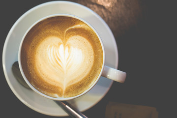 Hot coffee on a wooden table with selective focus, macro closeup