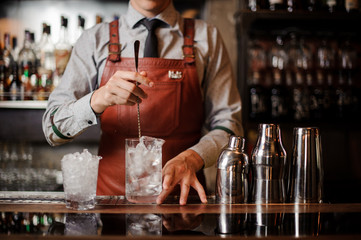 Bartender is making make a cocktail with ice