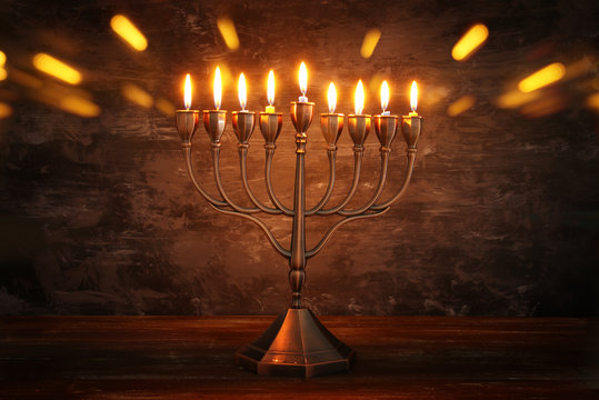 Low key image of jewish holiday Hanukkah background with menorah (traditional candelabra) and burning candles