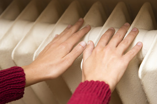 Hands Warming With Heating Radiator