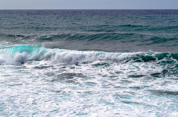 Coastal transparent sea/ocean crashing wave with foam on its top