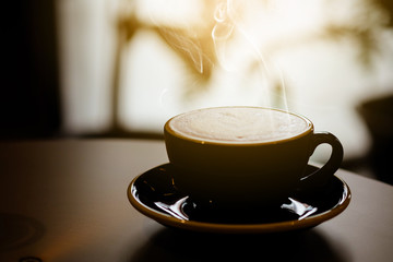 Hot coffee in black cup on the table