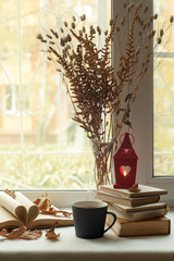 fall. cozy window with autumn leaves, a book, a mug of tea