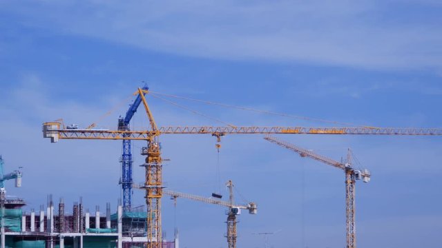 4k video of Crane moving construction panel with blue sky