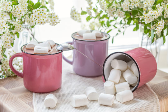 Marshmallows on top of hot cocoa in pink cups