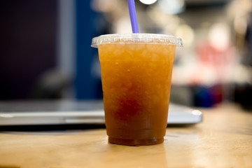 Fresh ice tea in plastic glass with straw