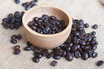 Heap of coffee beans on wooden bowl