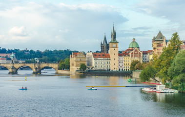 The Mill peninsula and the Charles Bridge in Prague in the Czech Republic at sunset. Boats on the...