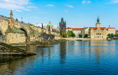 Fototapeta na wymiar Charles Bridge in Prague in the Czech Republic. Old Town Bridge Tower. The Mill peninsula. Sculptures on the Charles Bridge. The Vltava River
