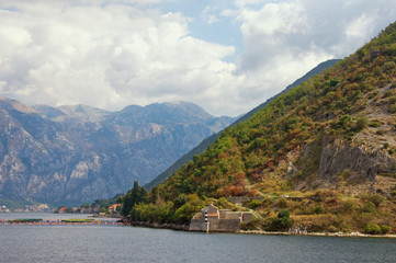 Picturesque autumn of Montenegro. View of the mountain with Church of Our Lady of the Angels on the coast of the Bay of Kotor (Adriatic Sea) near Stoliv village and fishing farm
