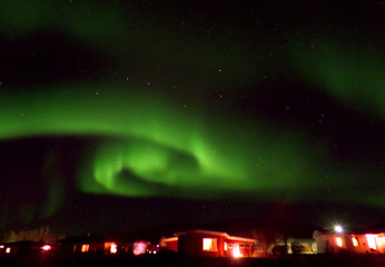 Swirling Aurora Borealis over a Small Town in the  Northern Part of Iceland