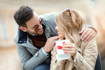 Couple in love.Man surprising his girlfriend with a gift.