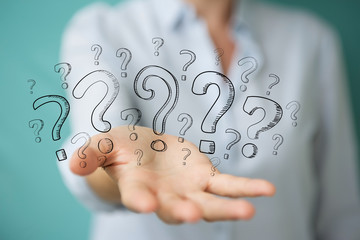 Businesswoman touching and holding hand drawn question marks