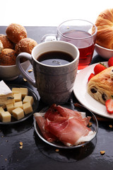 Obraz na płótnie Canvas Breakfast served with coffee, orange juice, croissants and strawberry, jam and tea.