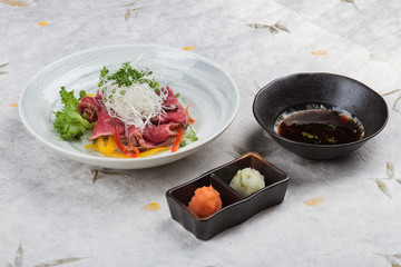 Sliced medium rare wagyu topping with sliced radish and scallion served with mince radish, carrot and Ponzu sauce on washi (Japanese paper).