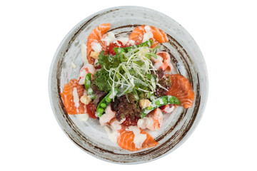 Isolated top view of Salmon and shrimp salad with red oak, pea, crouton with mayonnaise topping with wild rocket in ink painted ceramic bowl.