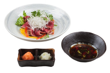Isolated Sliced medium rare wagyu topping with sliced radish and scallion served with mince radish, carrot and Ponzu sauce.