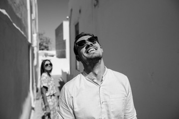 Happy couple hugging and laughing together with a view of Santorini, black&white photo