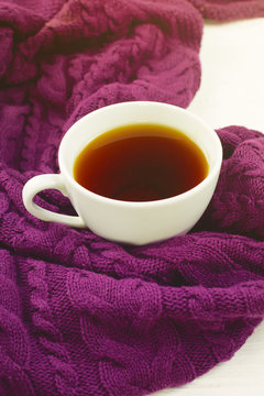 Cup of warm tea on a purple blanket. Selective focus.