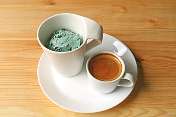 Cup of mint chocolate chip ice cream and one shot of espresso coffee for tasty Affogato served on wooden table 
