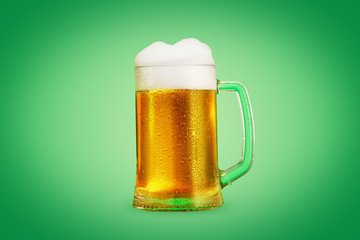Mug of beer close-up with froth over green background
