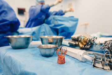Team of surgeons operating wearing lamp lighting electric cautery and flex clamp, heart surgery...