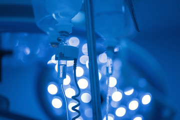 perfusion drip equipment hanging in hospital medical unit, blue background