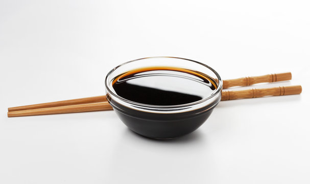 Soy sauce and chopsticks isolated on white background