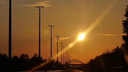 Sunset and telegraph poles along the road from the car
