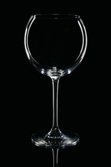 Empty round wine glass with reflection on black background