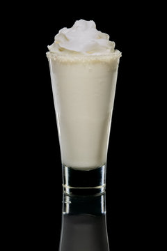Coconut cream and rum cocktail in highball glass isolated. Pina colada drink.