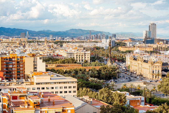 Top view on Barcelona city with Columbus monument, buildings and mountains on the background