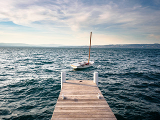 Pier at Geneva Lake with a sail boat in France