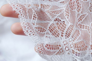 Beautiful delicate openwork white lace in hand