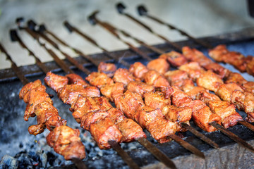 Appetizing pieces of pork meat are strung on skewers and have been frying on a grill