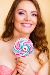 Woman holding colorful lollipop candy in hand.