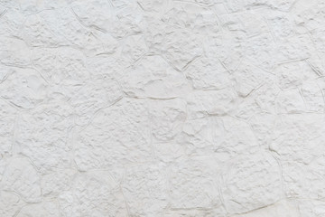 Surface is finished with white relief decorative plaster as a background