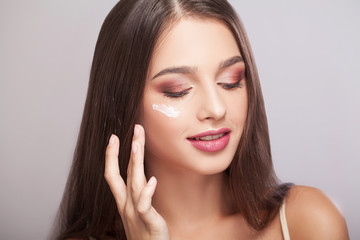 Fototapeta na wymiar Close-up of a Young Woman Getting Spa Treatment. Cosmetic Cream on a Cheek. Skin Care
