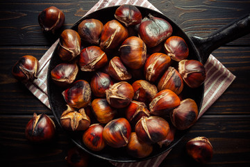 chestnuts in a pan on dark wooden background