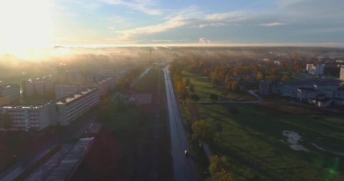 Beautiful Aerial Shot of Misty Sunrise in small town. Colorful clouds, fog above the city. 