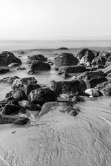 Atlantic beach with rocks in low tide at a foggy morning photo in black and white