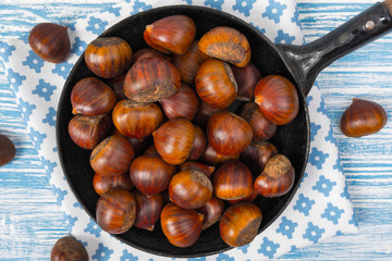 chestnuts in a pan on a wooden background