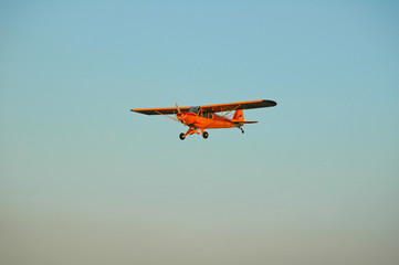 yellow single engine monoplane approaching for landing