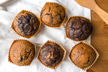 Freshly baked vanilla-chocolate muffins on the table, top view
